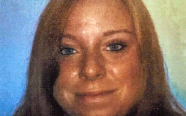 Junge Frau mit braunen Haaren lächelt in die Kamera