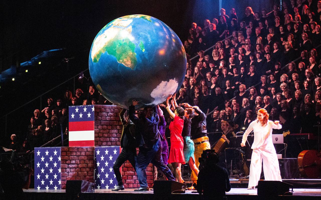 Schauspieler auf der Bühne; großer Chor im Hintergrund