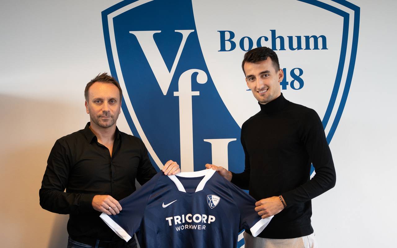 Zwei Männer lächeln und halten ein VfL Trikot in die Kamera