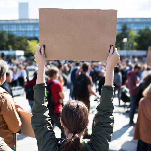 Streiken Demo Demonstration Frau hält Schild hoch