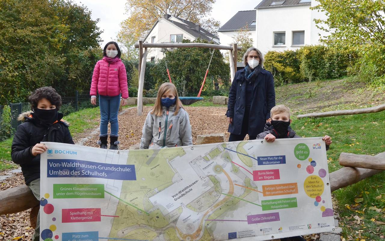 Einige Kinder stehen auf dem Schulhof und schauen in die Kamera