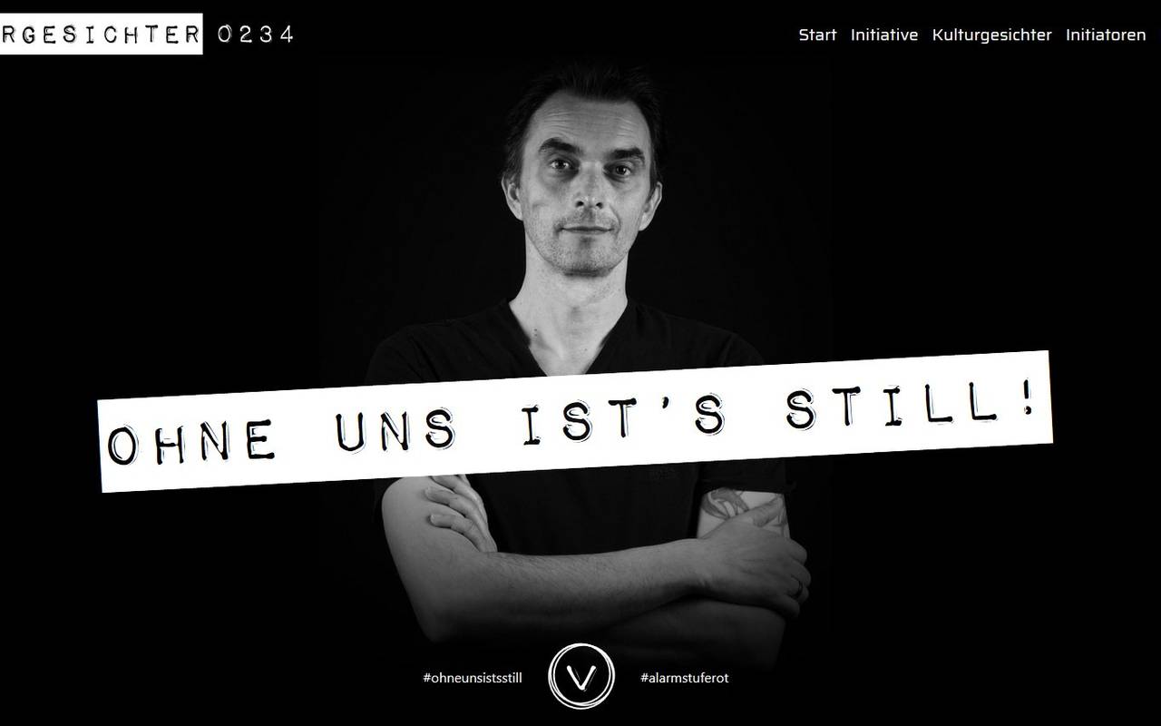 Ein Künstler steht vor schwarzem Hintergrund. Darüber der Slogan Ohne uns ists still.