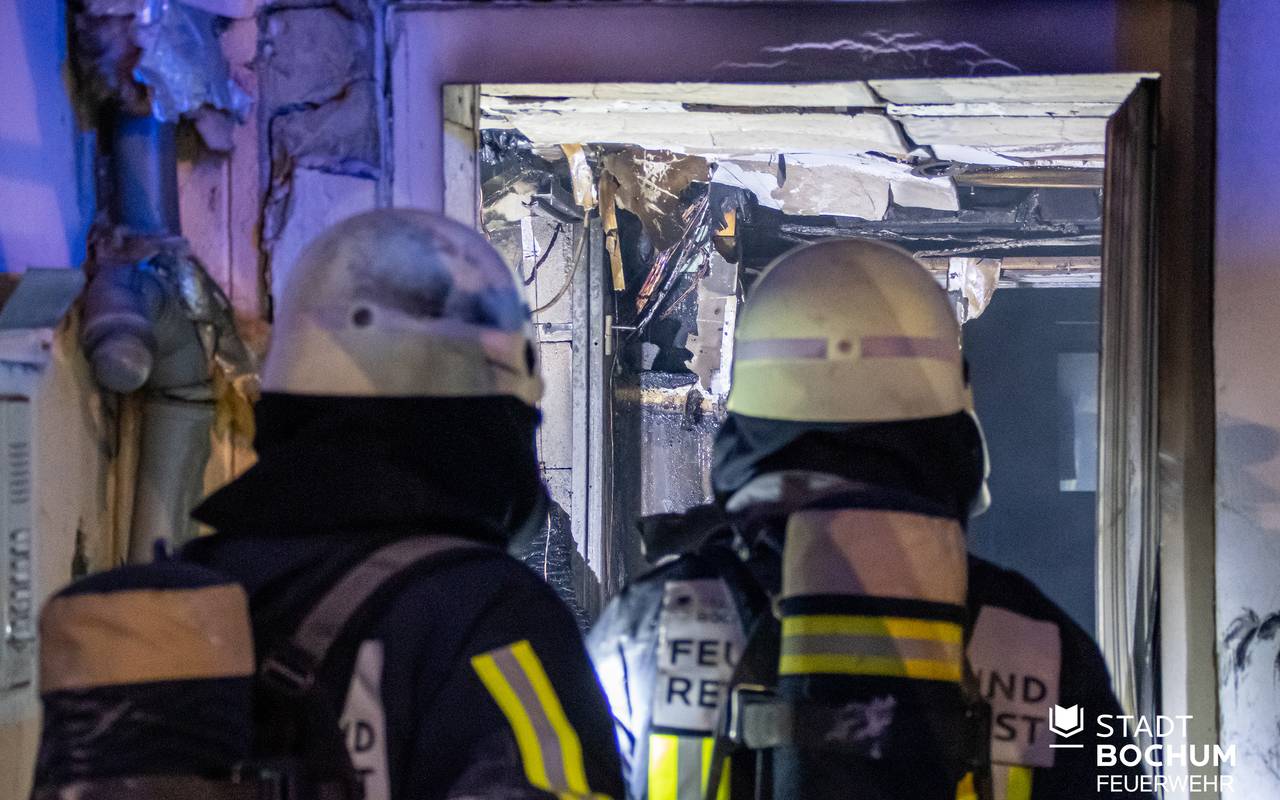 Feuerwehrleute im Innern des ausgebrannten Containers