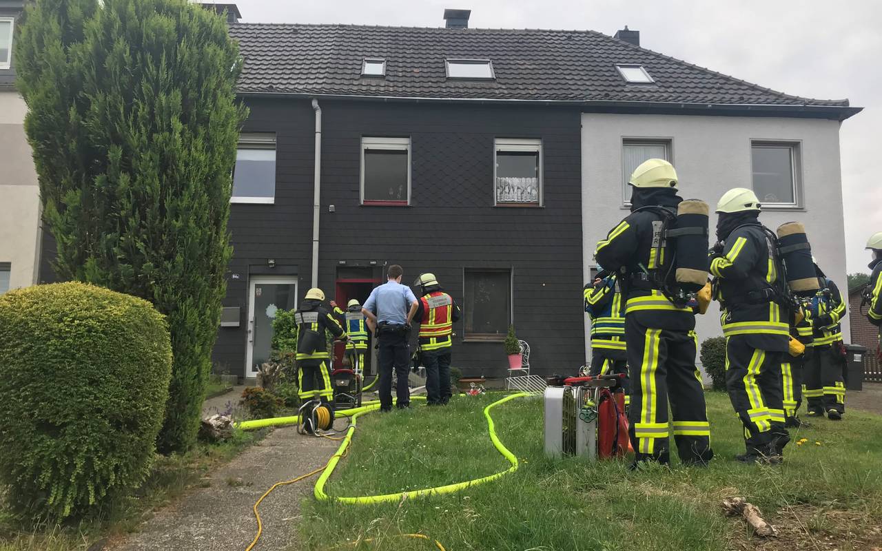 Feuerwehrleute stehen vor dem brennenden Keller