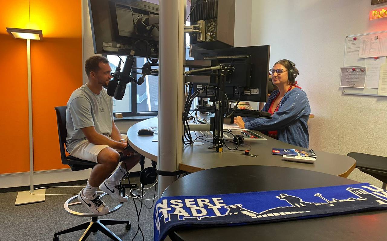 Zwei Personen sitzen im Radio Bochum-Studio vor den Mikrofonen.