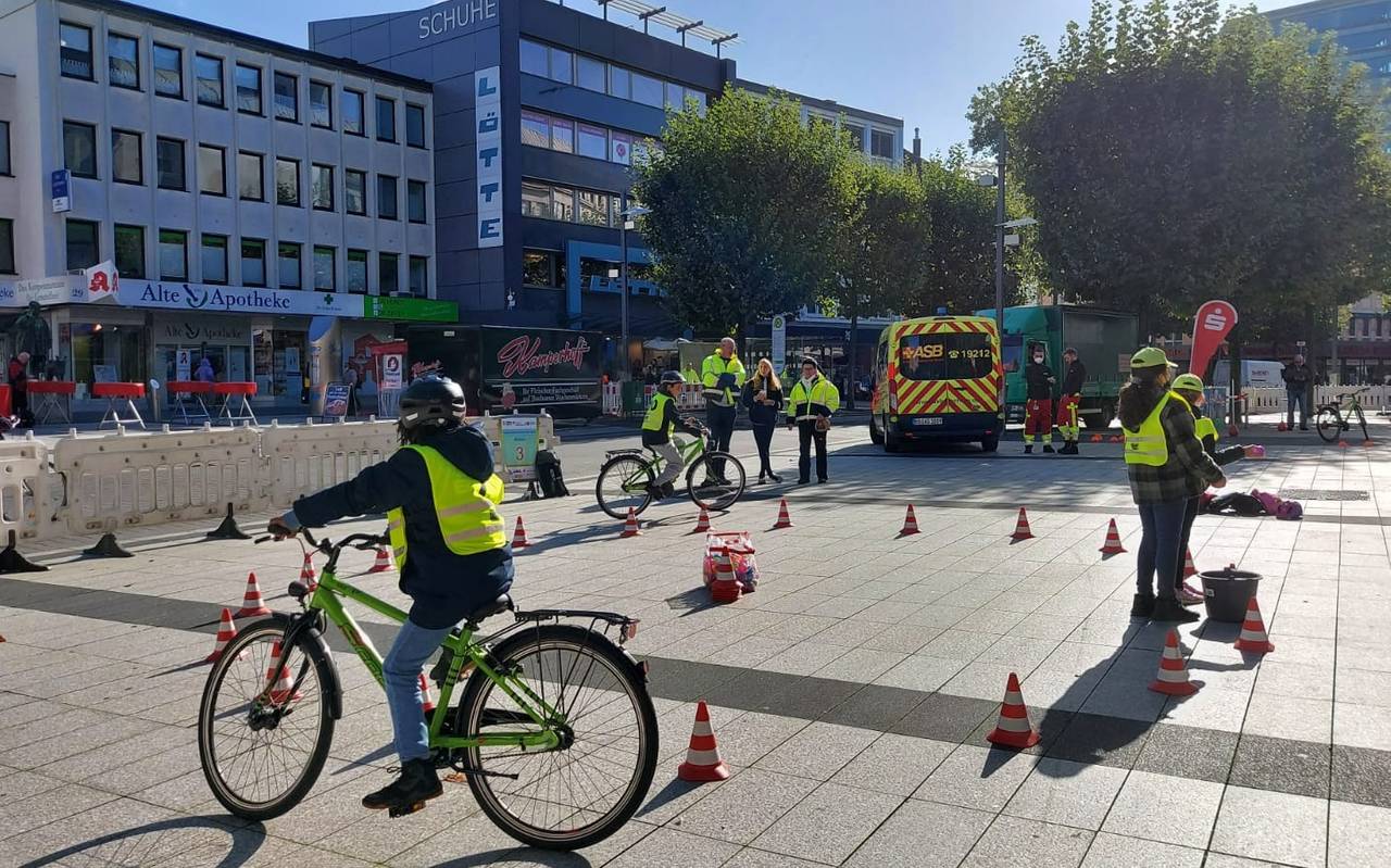 Kind mit gelber Warnweste sitzt auf einem Fahrrad