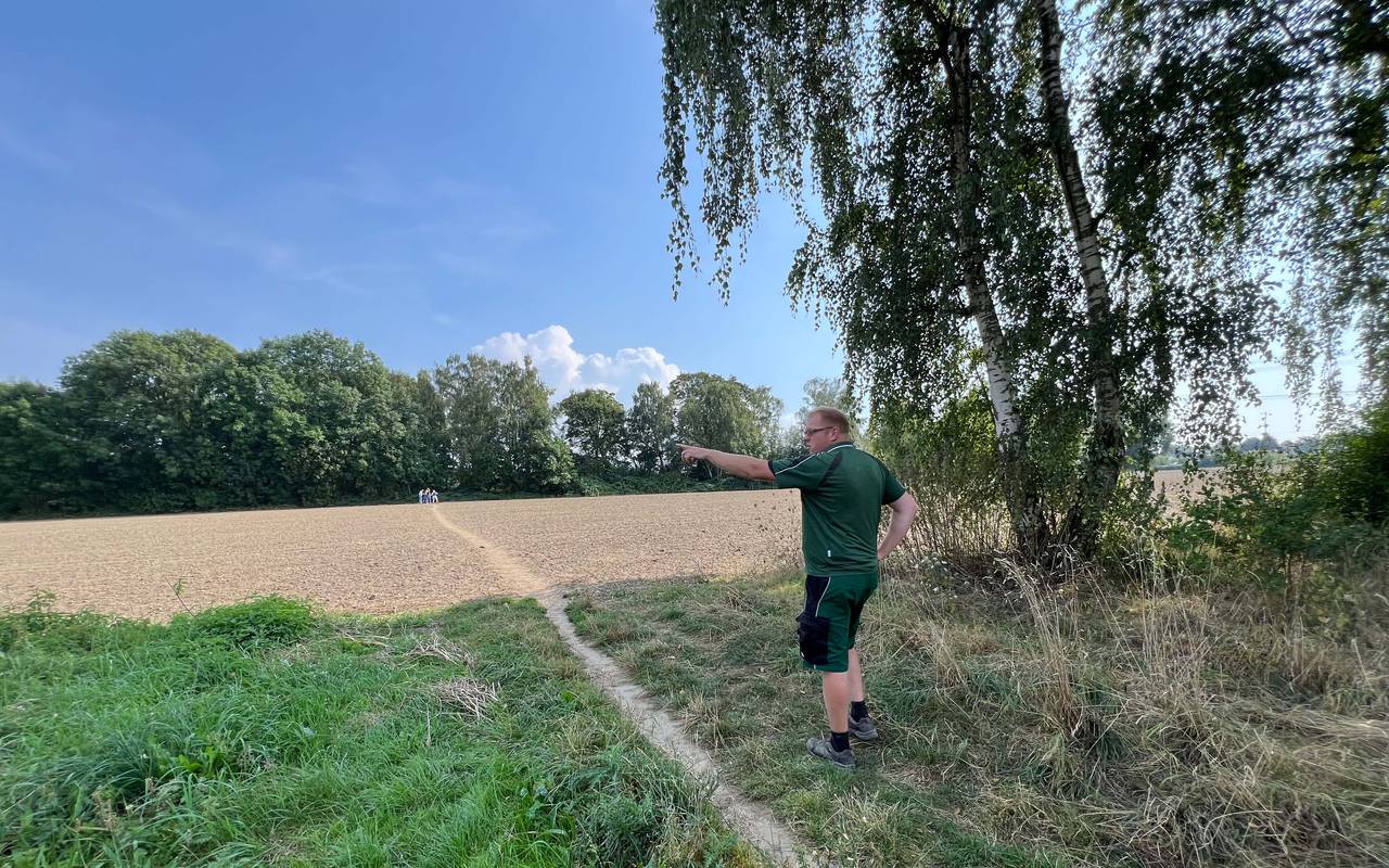 Dort wo eigentlich der Blühstreifen für Wildpflanzen und -tiere blühen sollte, steht Der Wattenscheider Landwirt Patrick Appelbaum und ärgert sic über Trampelpfade durch Fuß- und Spaziergänger:innen.
