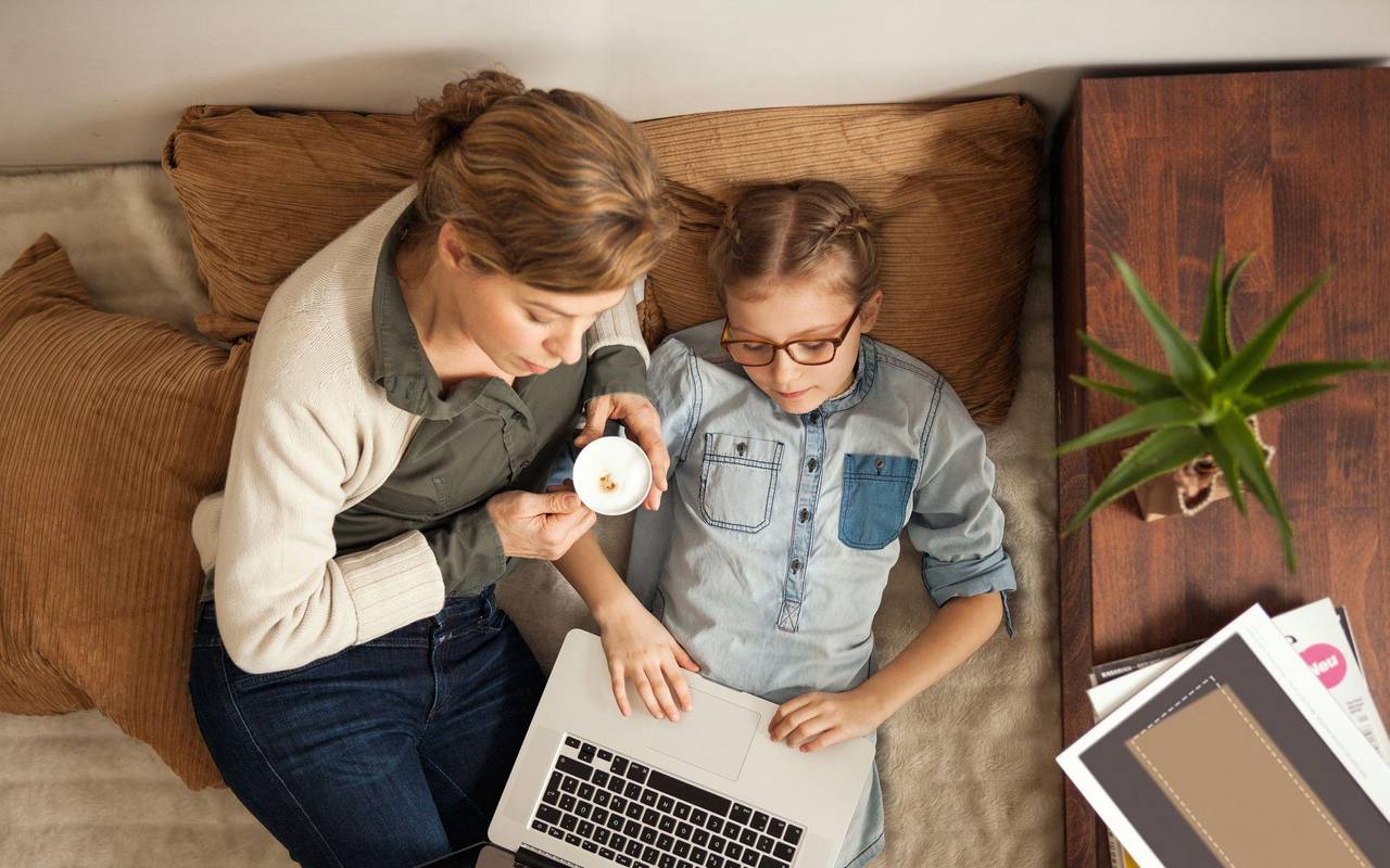 Mutter und Tochter schauen gemeinsam auf einen Laptop