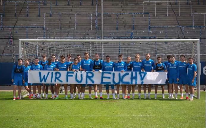 Die Mannschaft des VfL Bochum mit dem Banner "Wir für euch!"