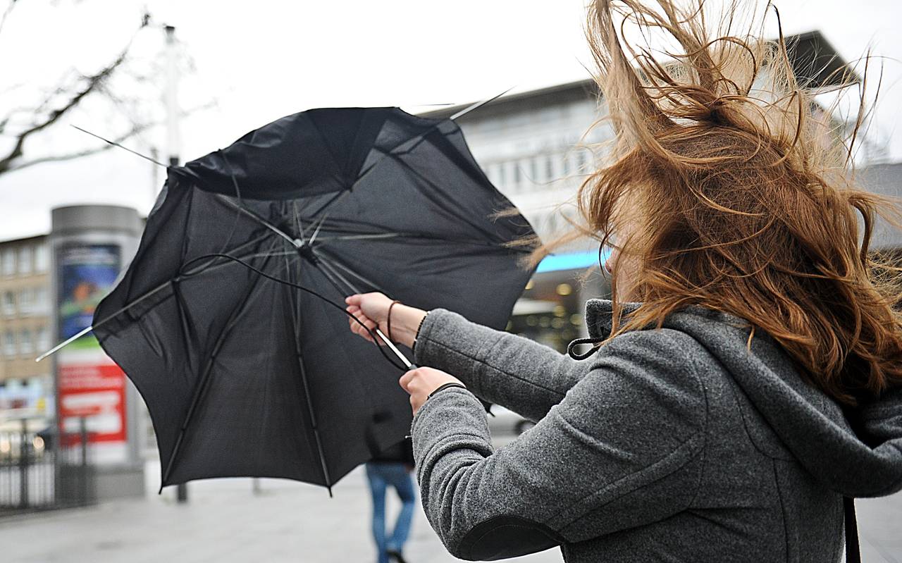 Eine Frau kämpft mit ihrem Regenschirm in der Essener Innenstadt gegen die Windböen eines Sturms.