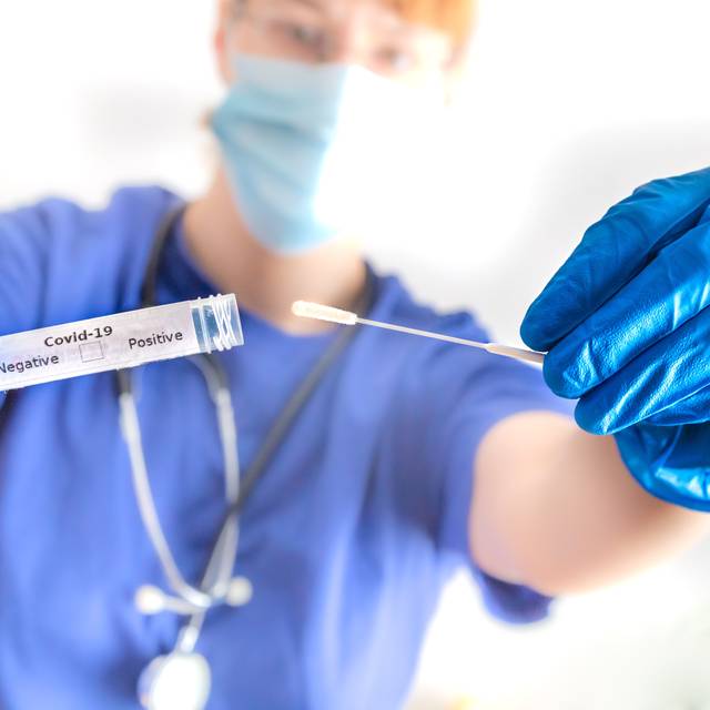 Ein Arzt hält eine Coronavirus-Abstrichröhre in der Hand.