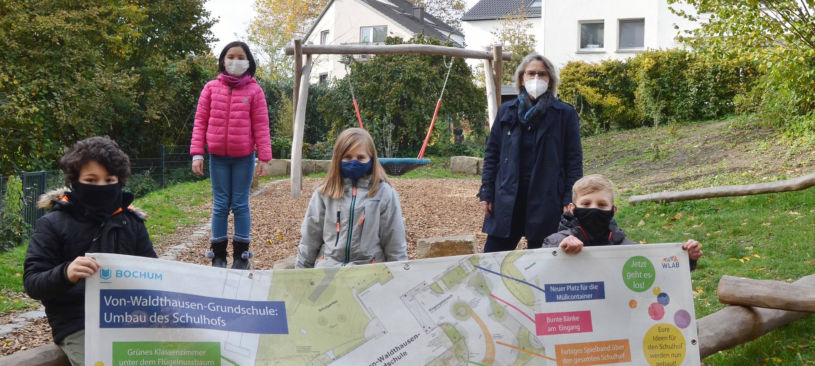 Einige Kinder stehen auf dem Schulhof und schauen in die Kamera
