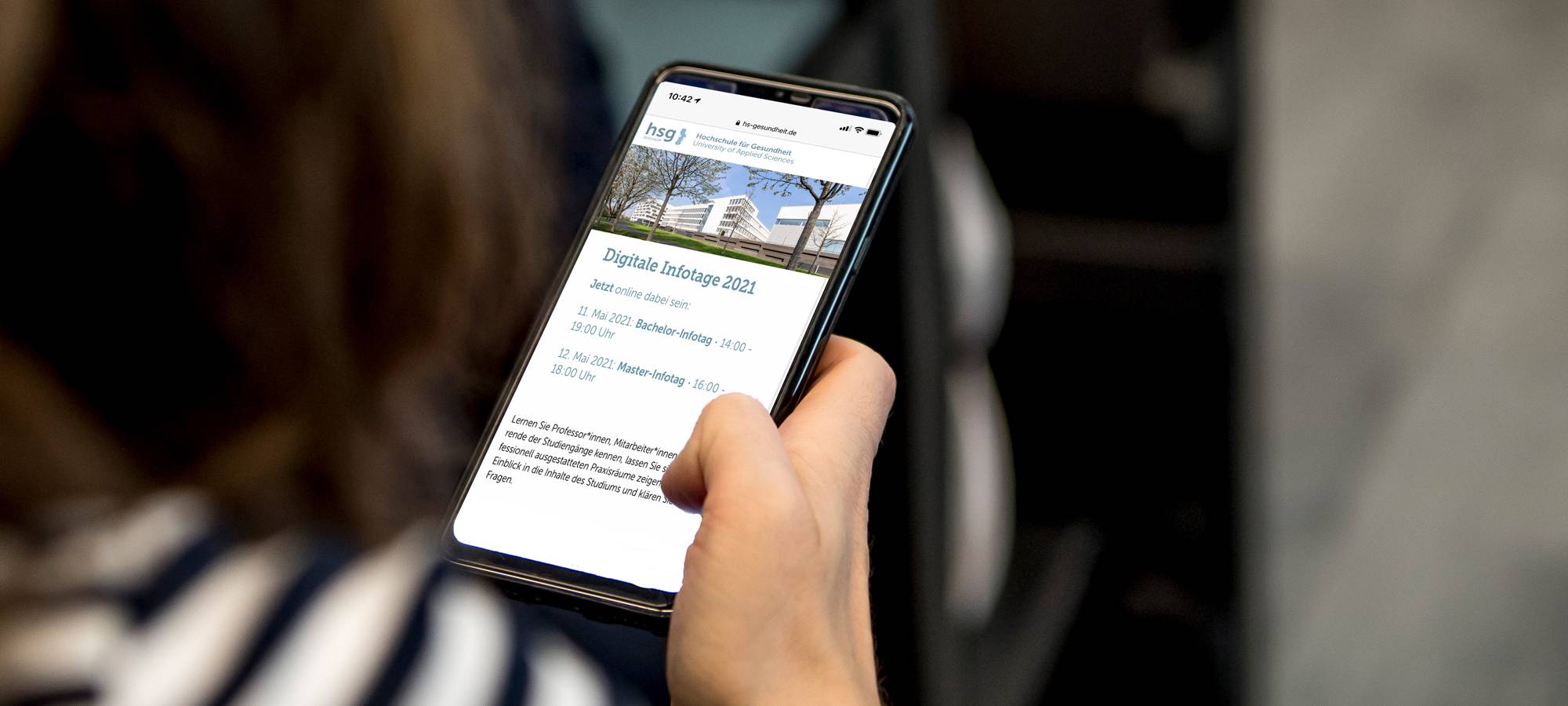 Auf einem Handy wird die Website der Hochschule für Gesundheit angezeigt