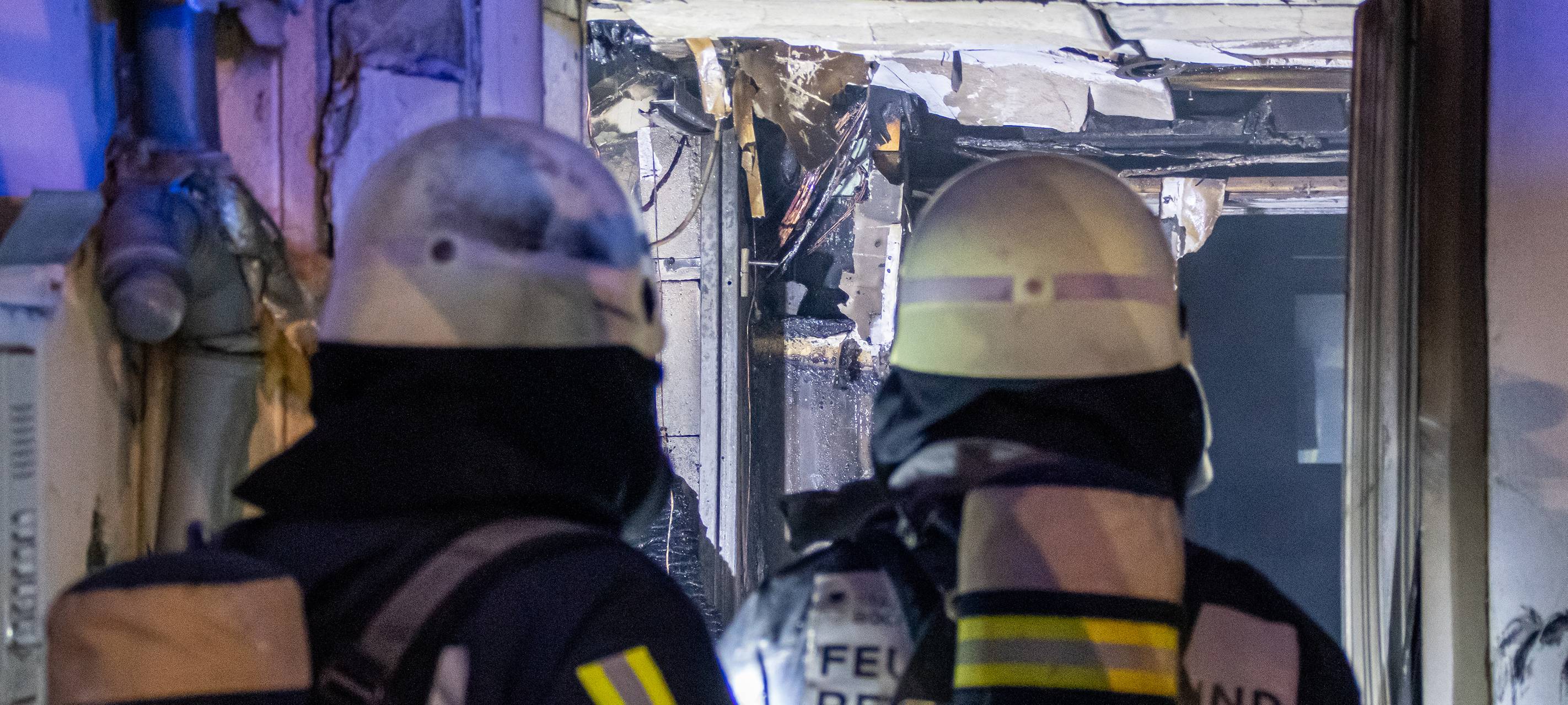 Feuerwehrleute im Innern des ausgebrannten Containers