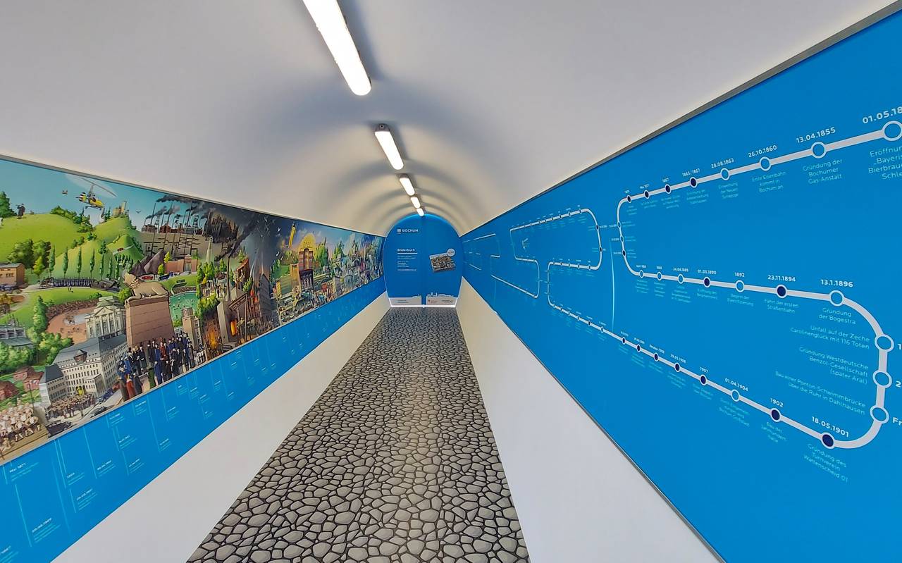 Langer Tunnel mit einem Wimmelbild auf der linken Seite.