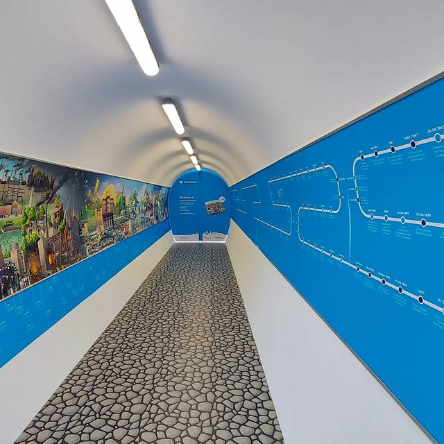 Langer Tunnel mit einem Wimmelbild auf der linken Seite.