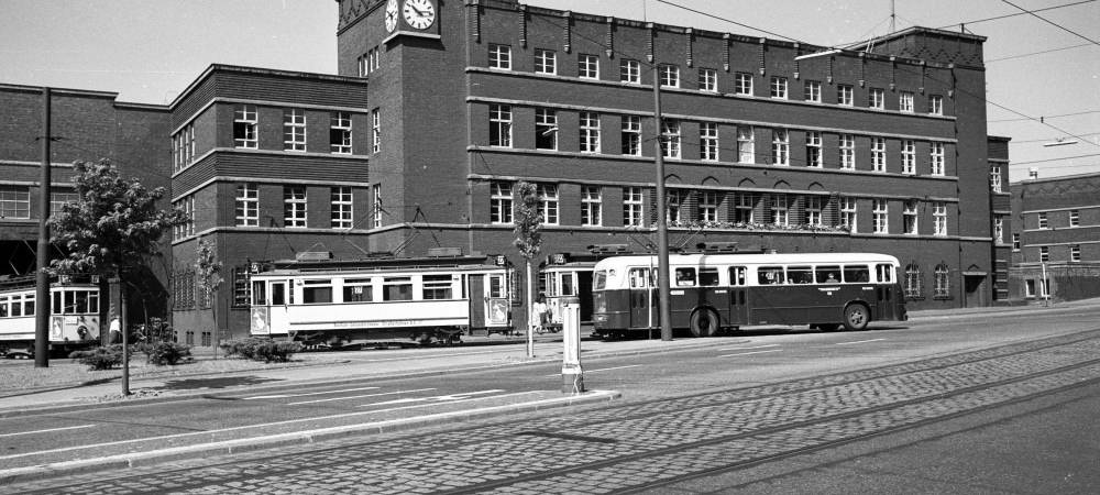 Alte Straßenbahnen vor einem Haus