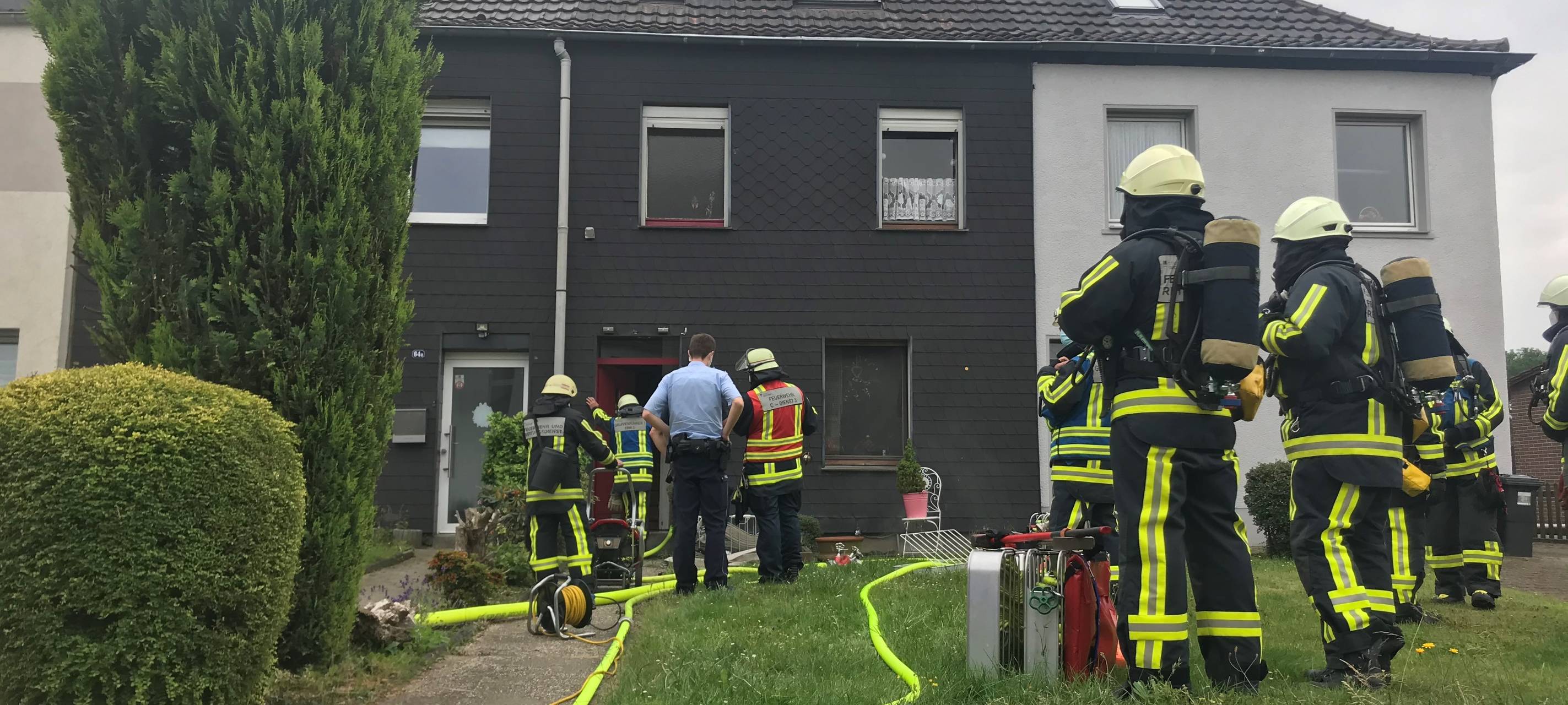 Feuerwehrleute stehen vor dem brennenden Keller