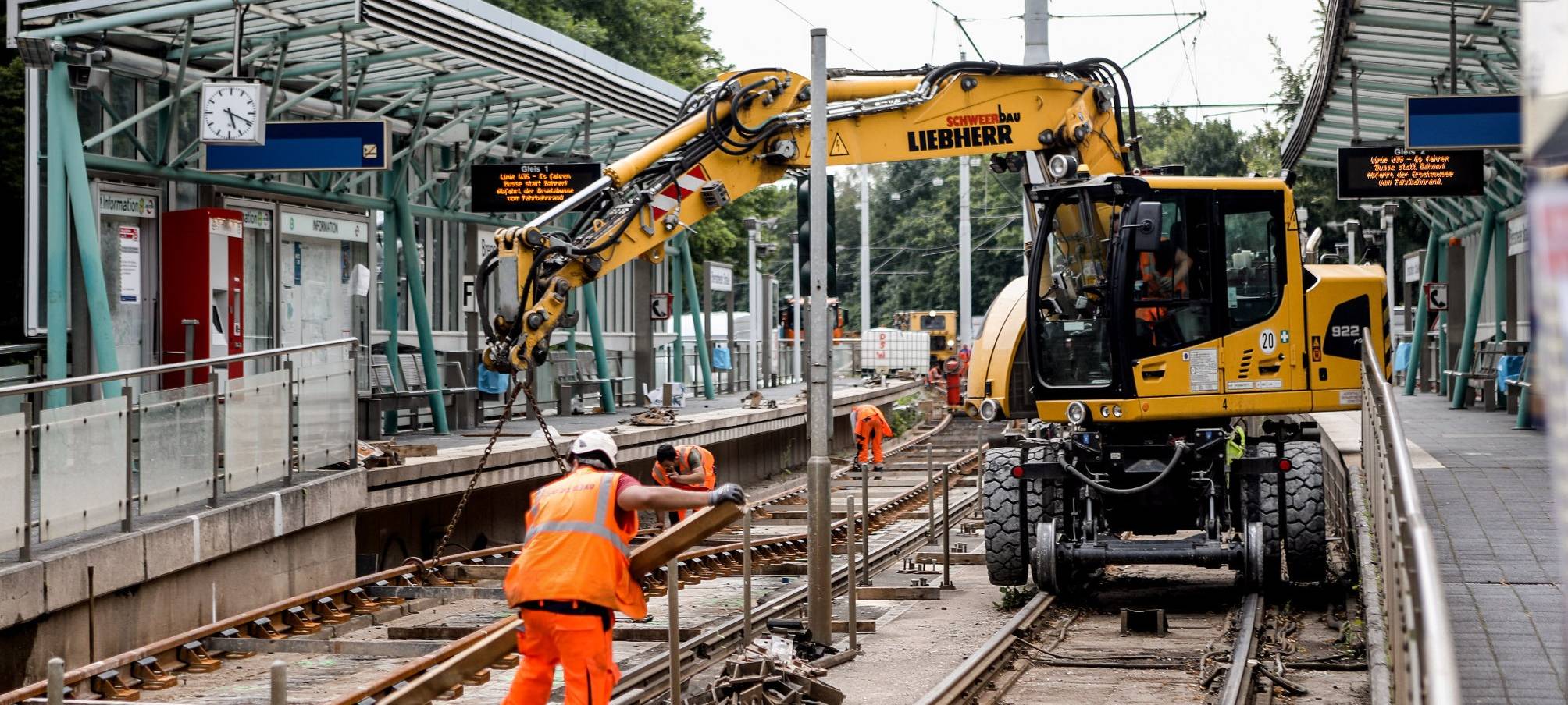 Bauarbeiter stehen in den Gleisen zwischen zwei Haltestellen.