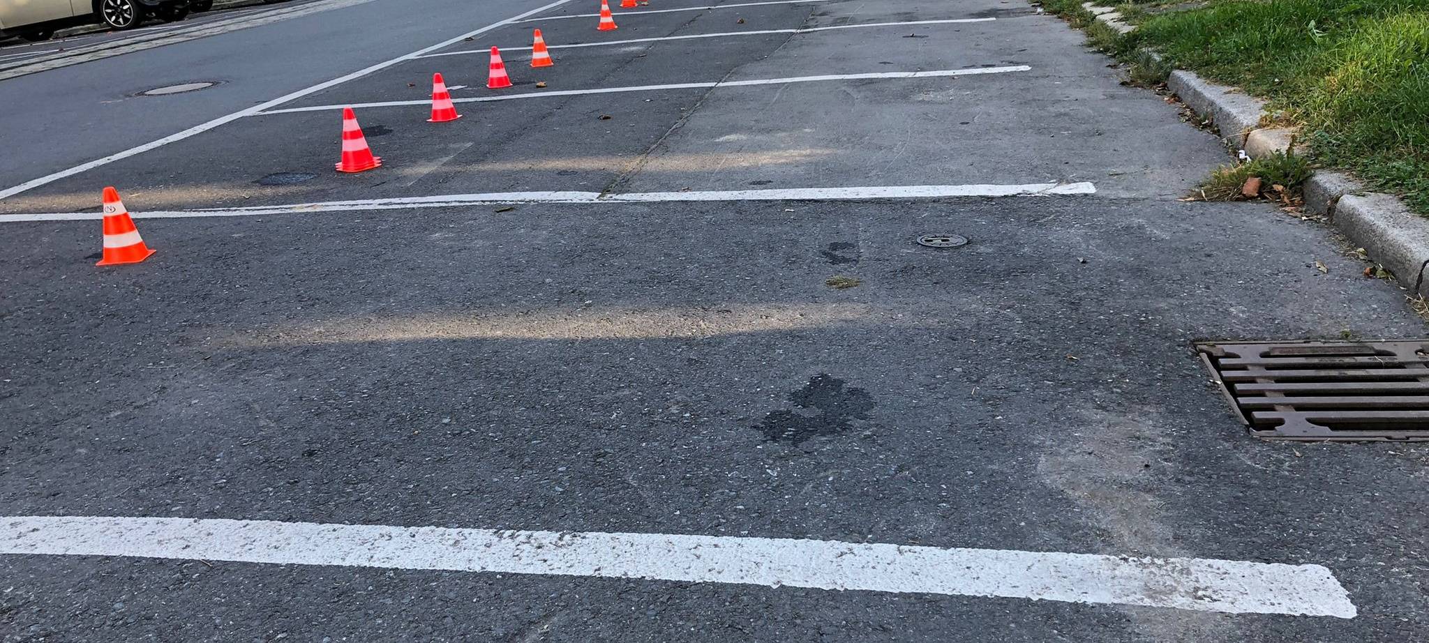 Vier Parkstreifen mit Hütchen eingezäunt.