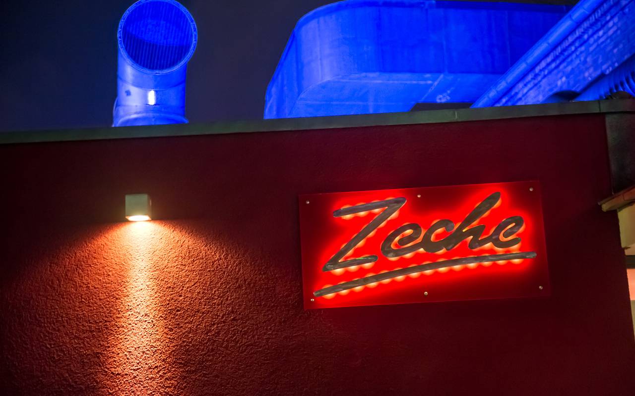 Das Logo "Zeche" leuchtet rot im Dunkeln