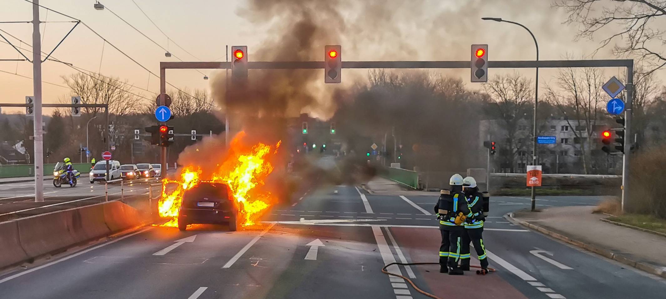 Hohe Flammen schlagen aus Auto mitten auf der Straße.