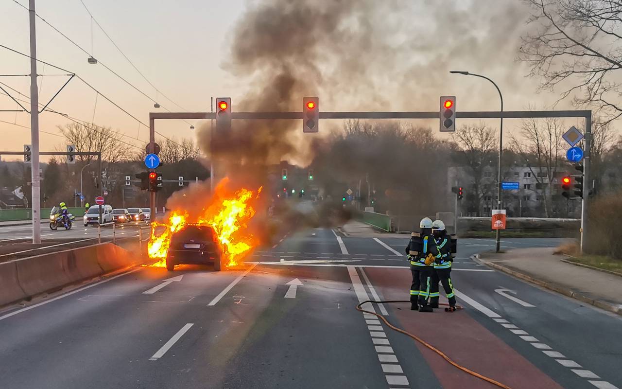 Hohe Flammen schlagen aus Auto mitten auf der Straße.