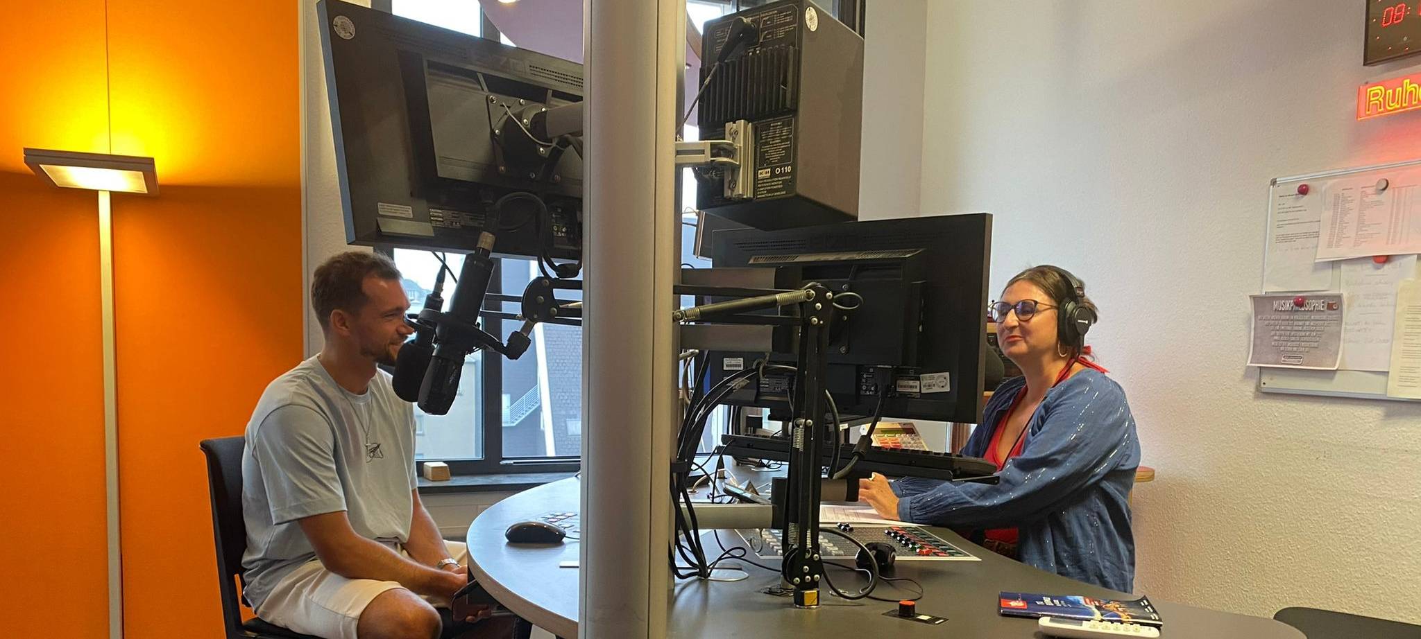 Zwei Personen sitzen im Radio Bochum-Studio vor den Mikrofonen.