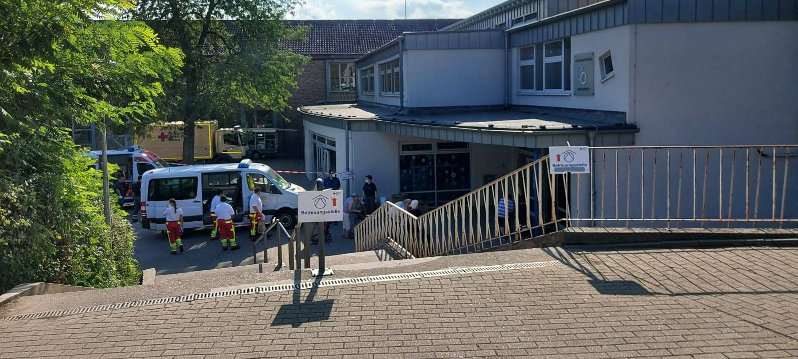 Schule von außen, davor Einsatzwagen