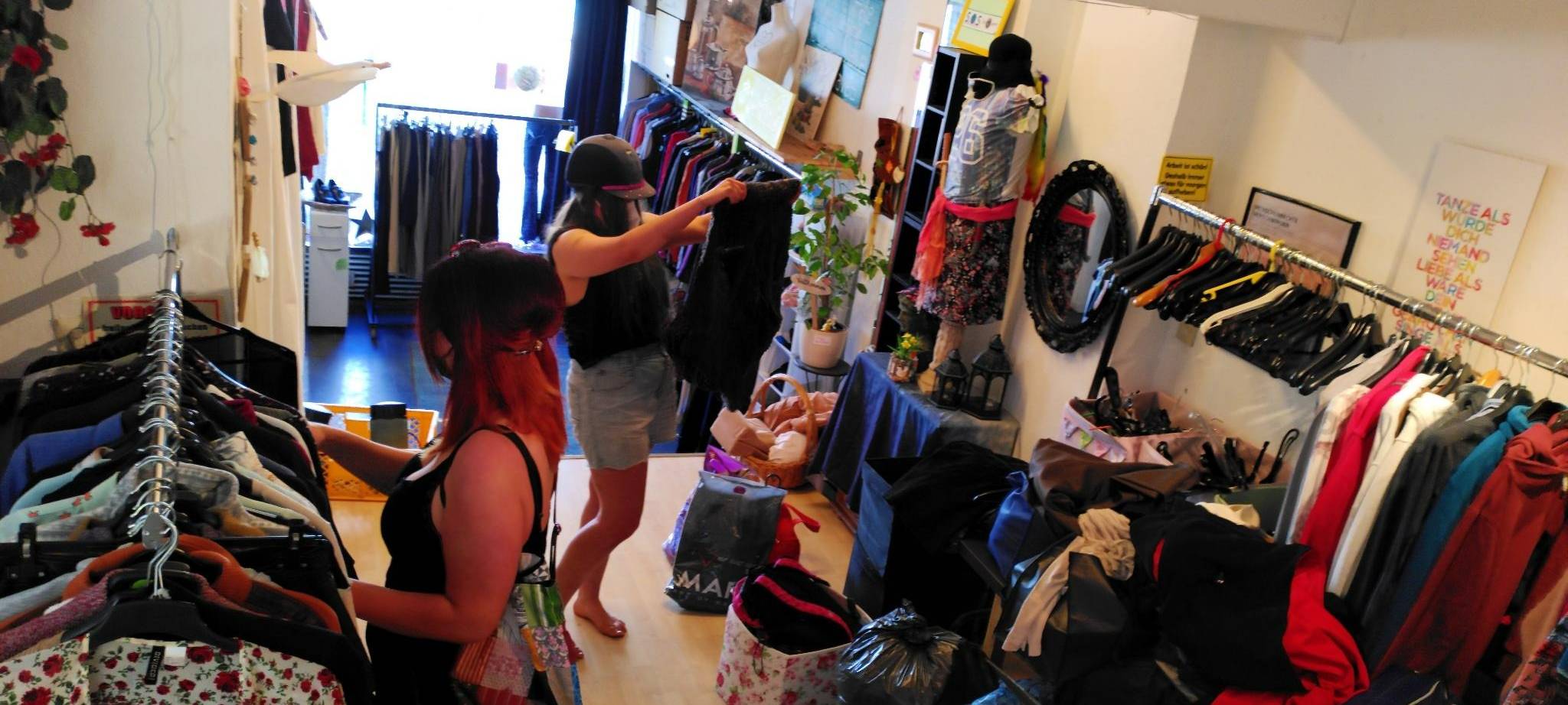 Frauen stöbern an Kleiderstangen