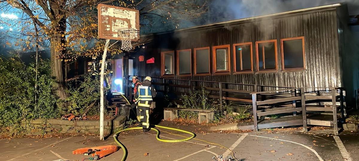 Feuerwehrmänner vor brennendem schwarzen Pavillon