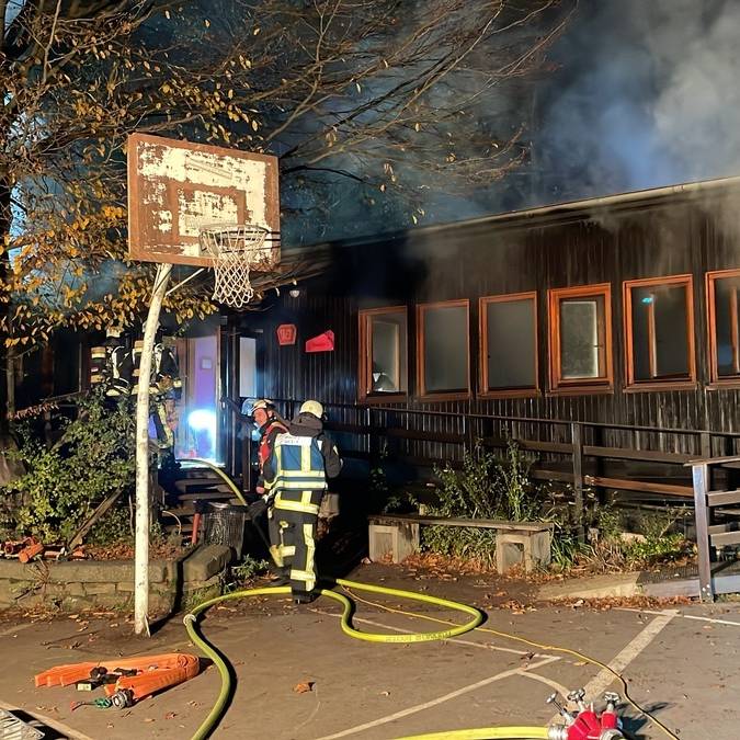 Feuerwehrmänner vor brennendem schwarzen Pavillon