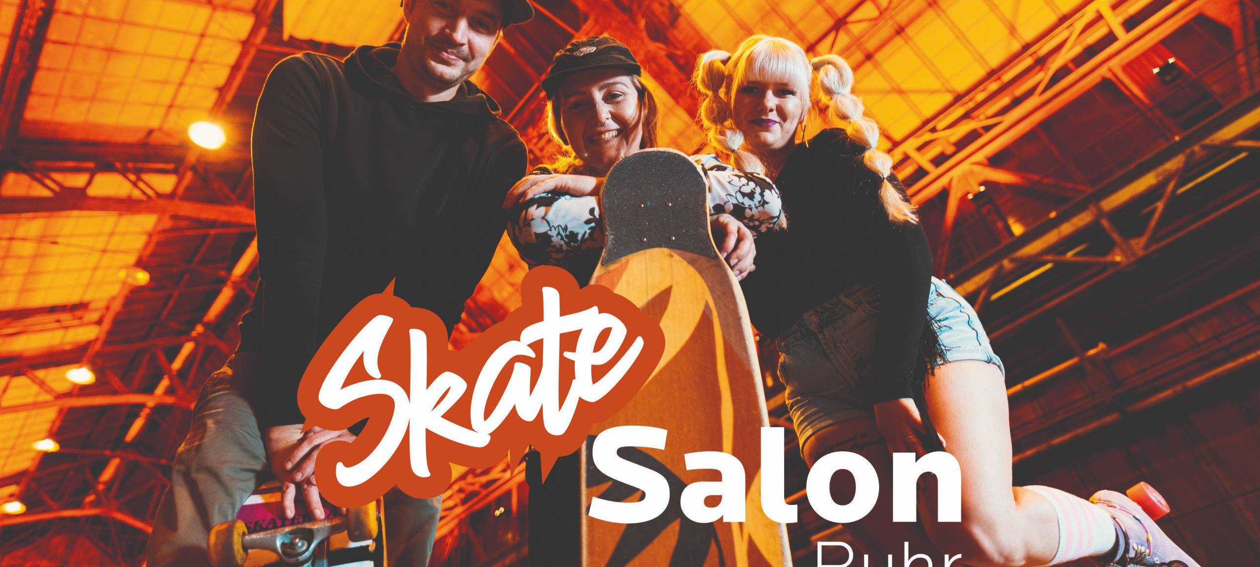 Leute mit Skateboards lächeln in die Kamera.