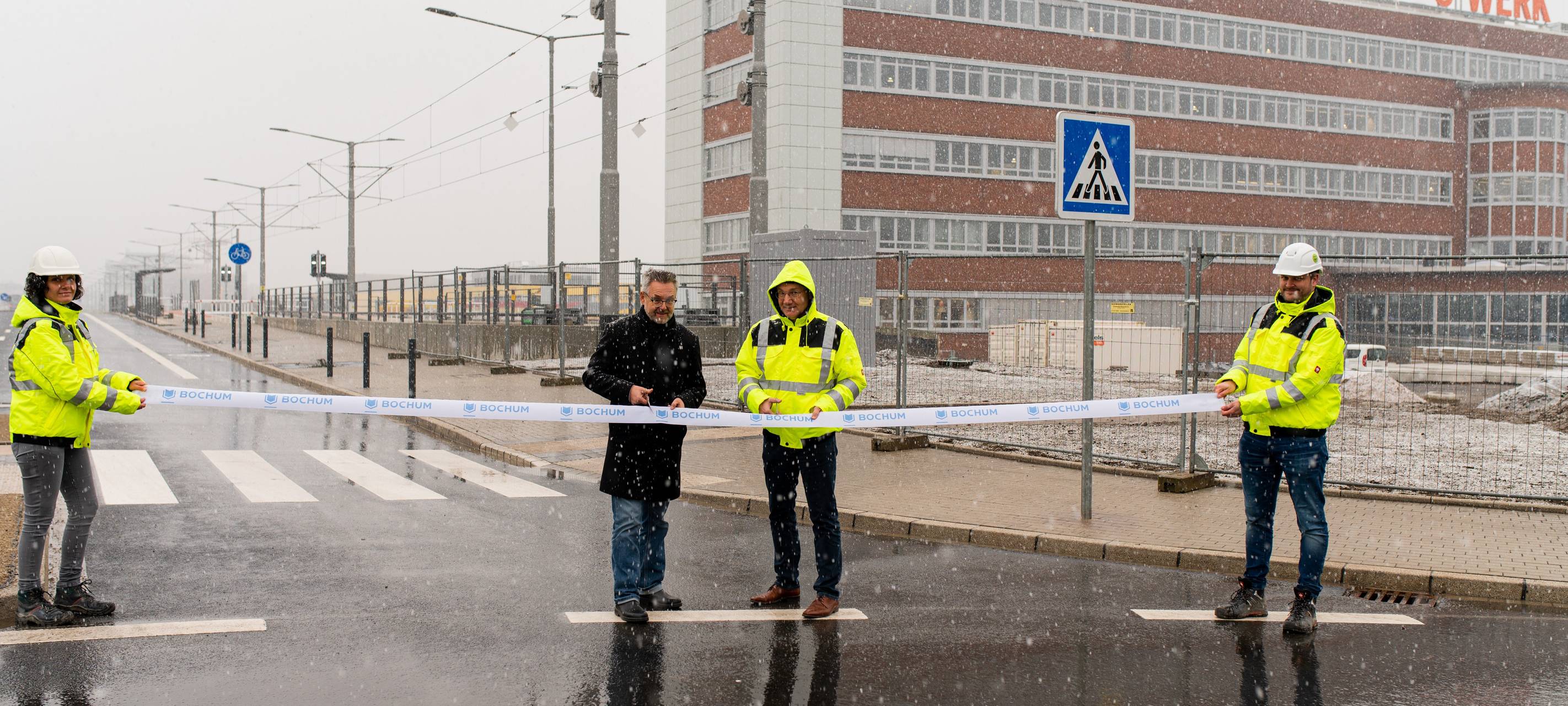 Menschen schneiden ein gelbes Band durch