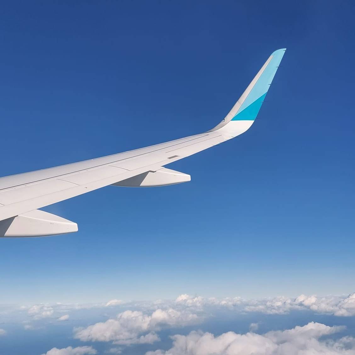 Flugzeug-Flügel über den Wolken aus Sicht eines Passagiers