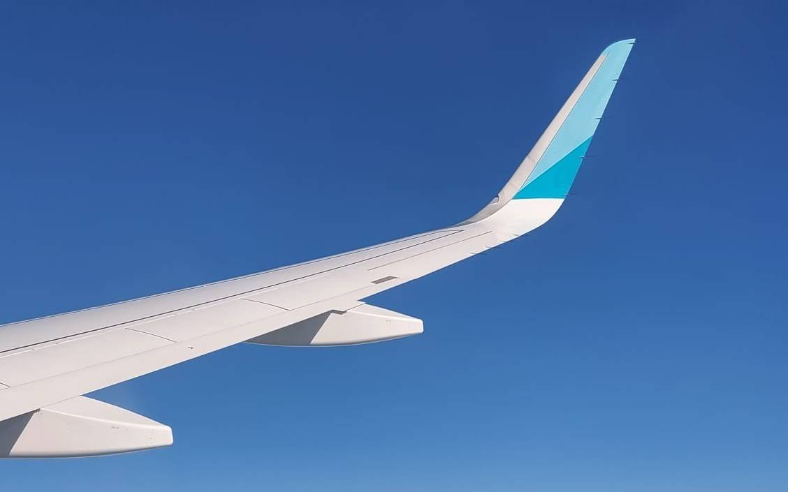 Flugzeug-Flügel über den Wolken aus Sicht eines Passagiers