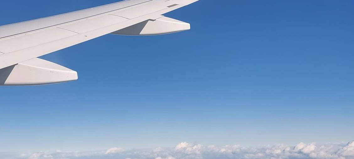 Flugzeug-Flügel über den Wolken aus Sicht eines Passagiers