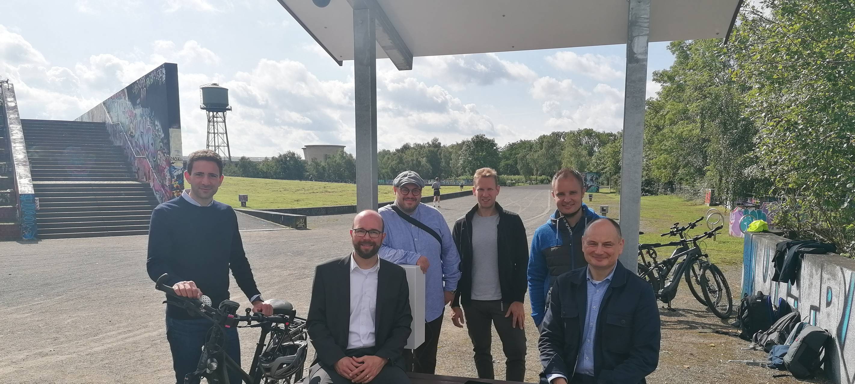 Akteure sitzen auf der smarten Sitzbank im Westpark