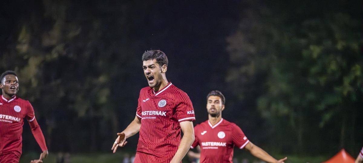 Ein Fußballspieler im roten Trikot jubelt