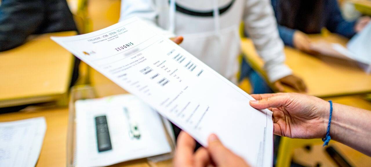 Die Klassenlehrerin übergibt das Zeugnis eines Schülers der Klasse 9b der Freiherr-vom-Stein-Schule in Gütersloh.