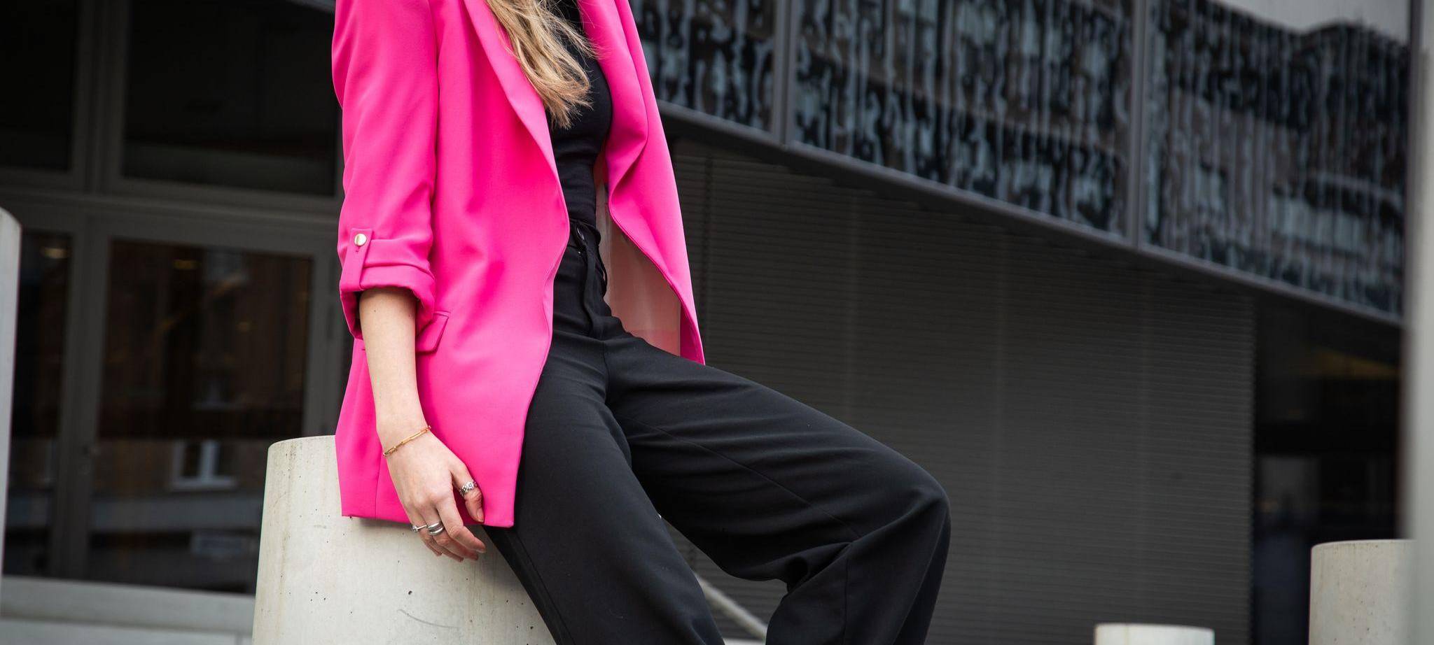 Eine junge Frau trägt einen Neon Pink Blaser