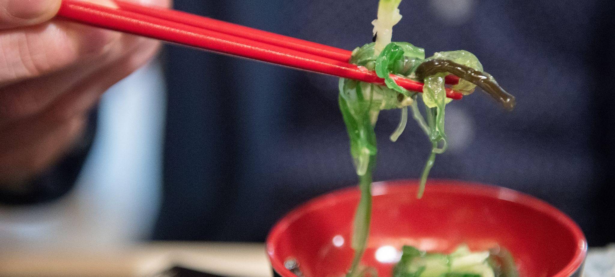 Ein Mann isst einen Wakame-Algensalat