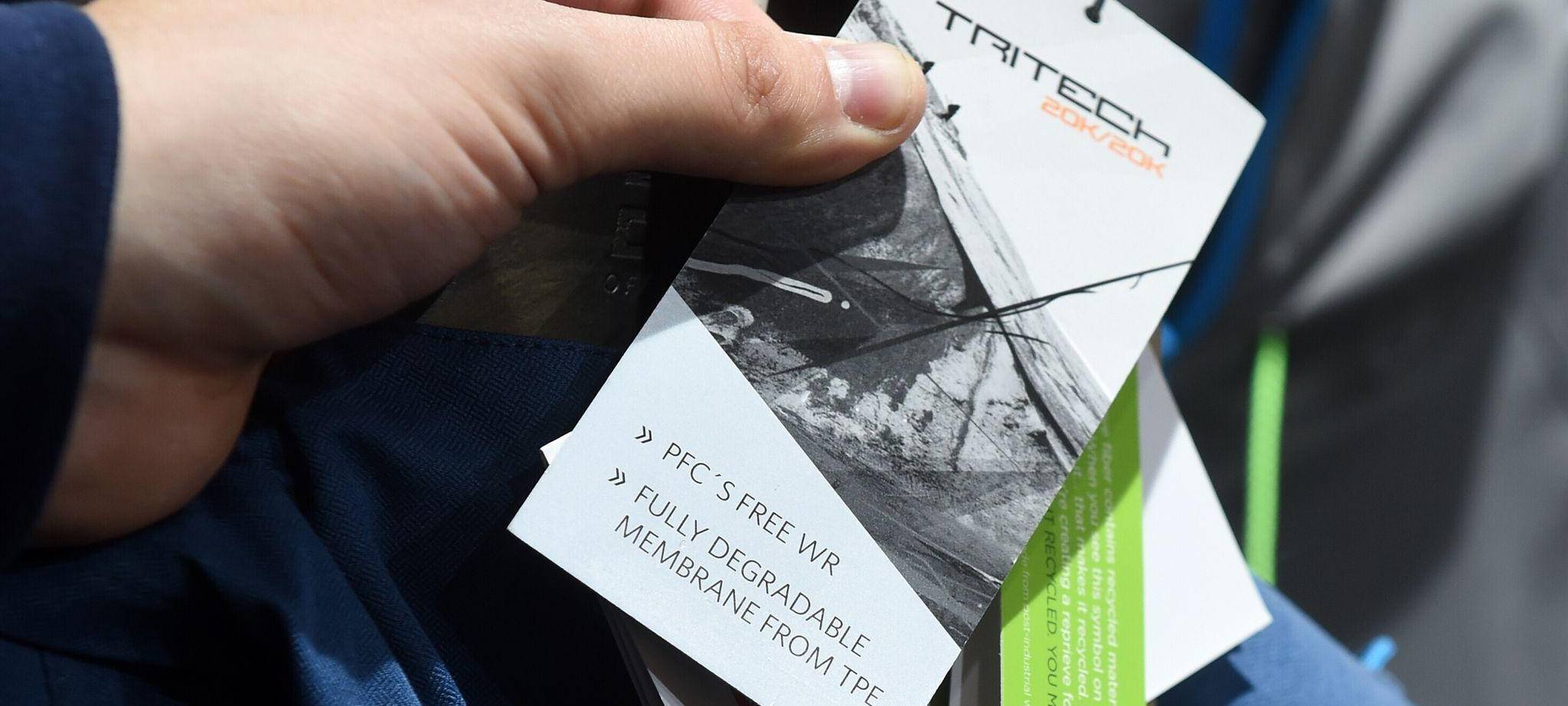 Ein Mann hält ein PFC-frei-Etikett an einer Sportkleidung