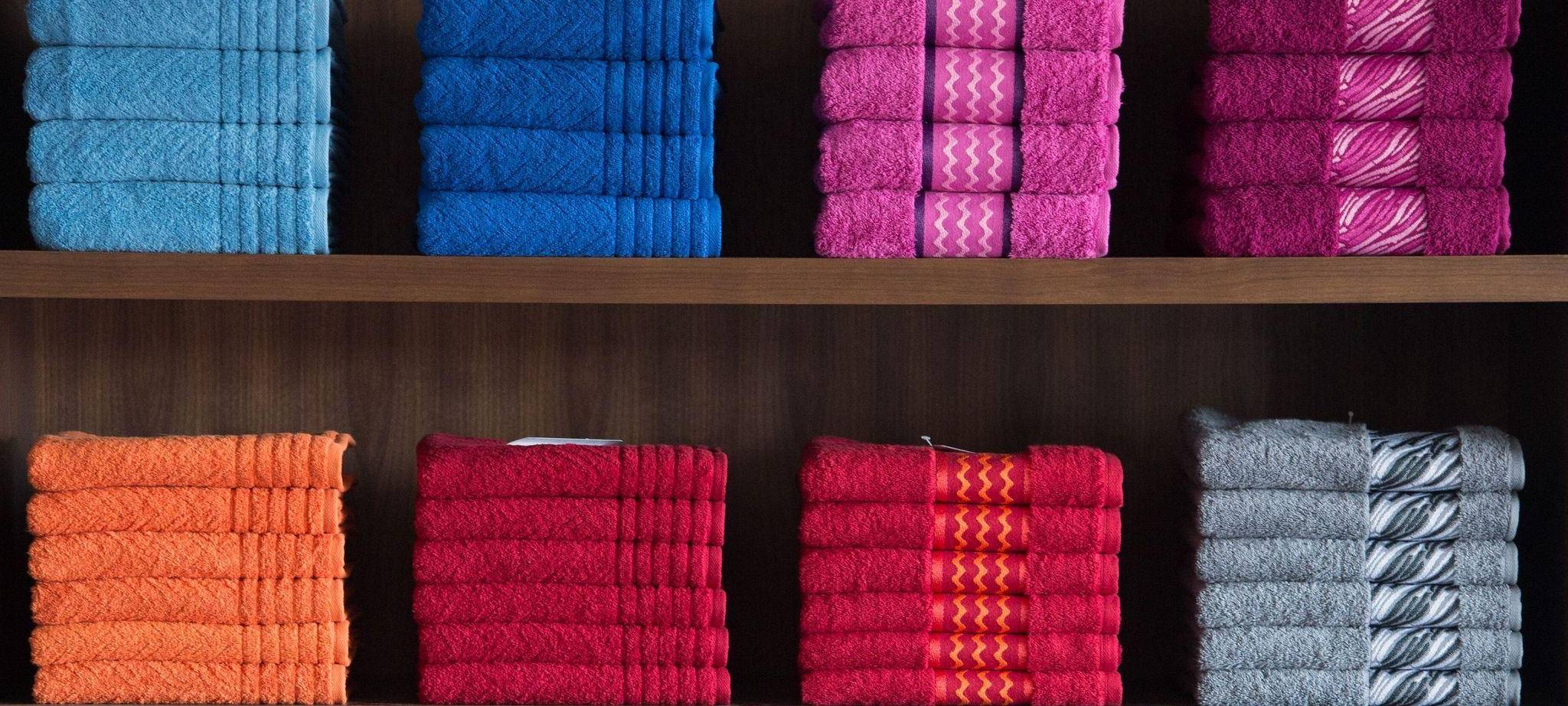 Nach Farben sortierte Handtücher in einem Regal