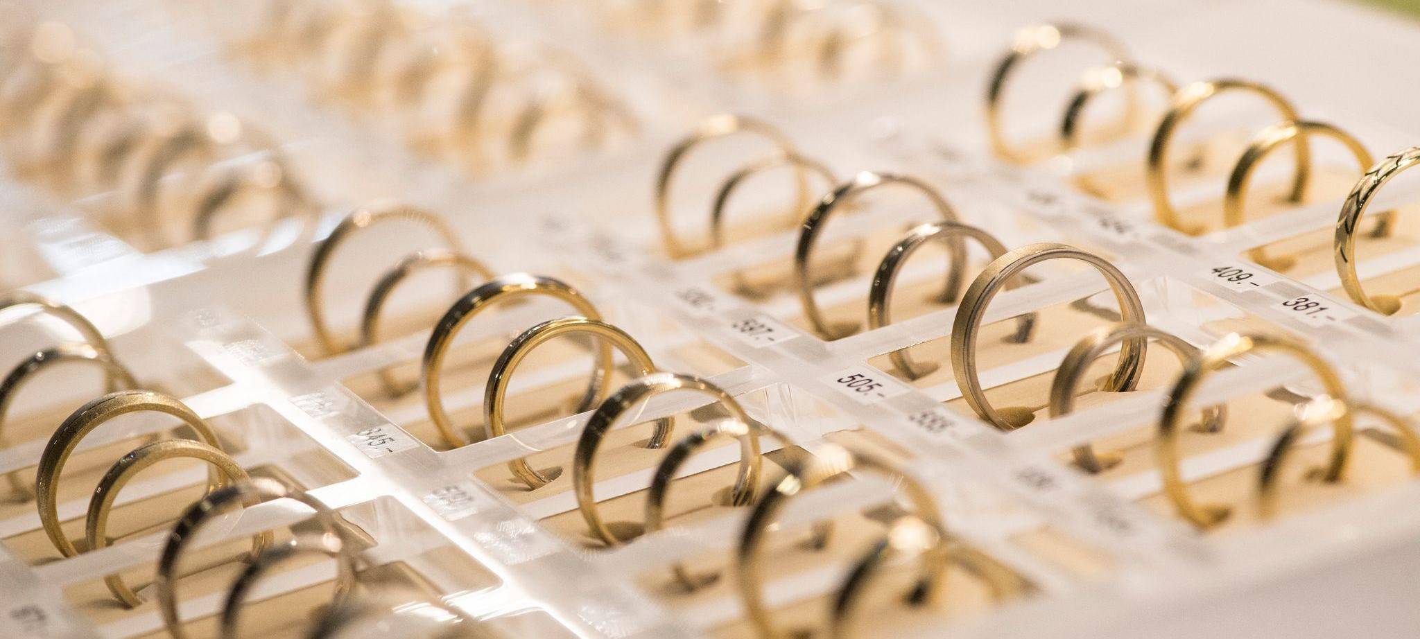 Eheringe liegen bei einer Hochzeitsmesse in einer Vitrine