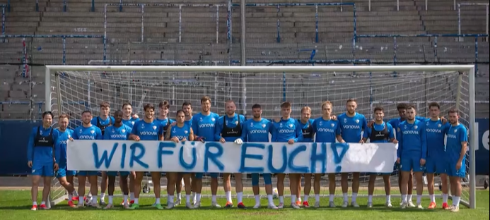 Die Mannschaft des VfL Bochum mit dem Banner "Wir für euch!"