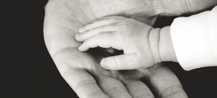 Eine große Hand hält eine kleine Hand